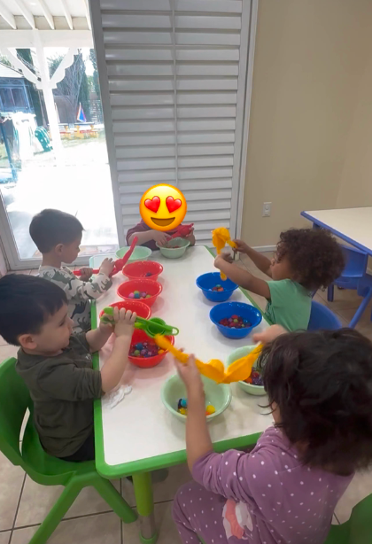 Children playing with pom-poms and funnels at Fairy Tale Child Care